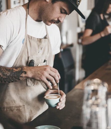 man preparing coffee in a cafe